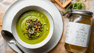 A bowl of nourishing green soup and a jar of OWL Chicken Broth Elixir