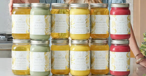 Bone broth cleanse featuring a variety of nutrient-rich elixirs and mylkshakes, neatly stacked in glass jars on a kitchen counter.
