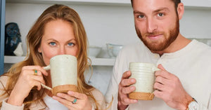 Bone broth cleanse enjoyed by a couple sipping from handcrafted ceramic mugs in a cozy kitchen setting
