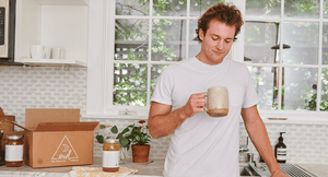 Man sipping OWL Bone Broth in the kitchen