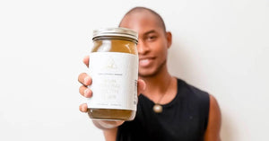 Collagen bone broth held in hand, jar label prominently displayed with a white background