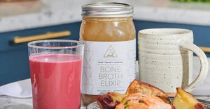 Bone broth cleansing with beef bone broth elixir, roasted vegetables, and a vibrant beet drink on a kitchen counter