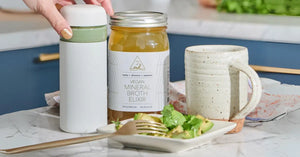 Detox with bone broth using vegan mineral broth elixir served alongside avocado salad and a ceramic mug