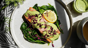 Salmon with Creamy Avocado Sauce on top of Sautéed Spinach