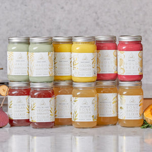 Broth cleanse featuring an assortment of bone broth elixirs and nutrient-rich mylkshakes in glass jars with silver lids.